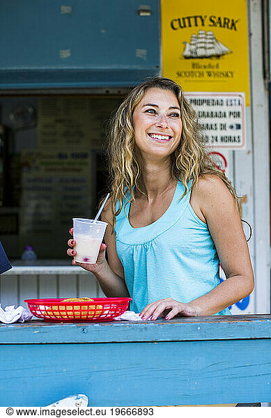 A young woman smiles while sitting at the bar of a small restaurant in Puerto Rico.