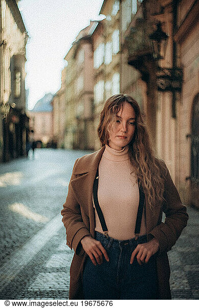 A young woman walks in the morning in sunny Prague