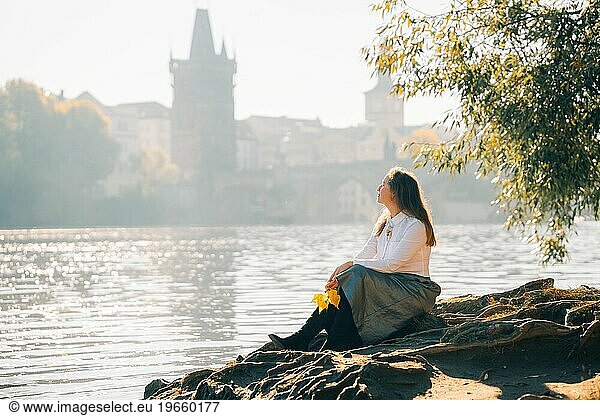 A young woman walks through the morning autumn sunny Prague