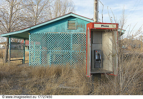 Abandoned old phone booth and deserted store by the roadside.