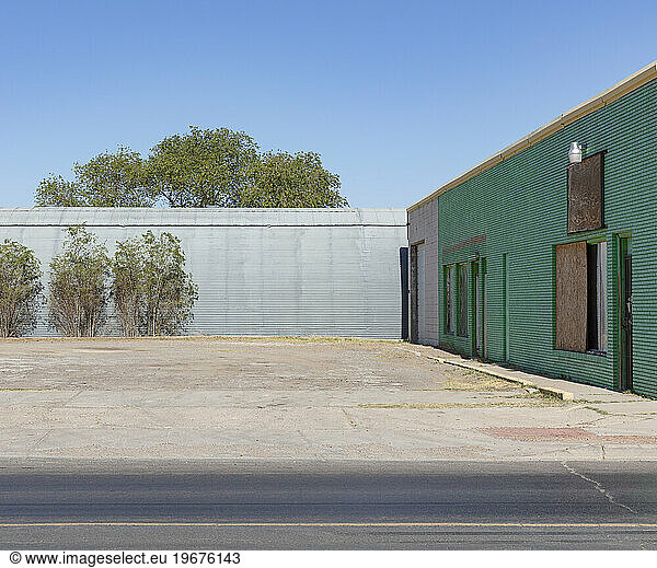 Abandoned warehouse and buildings with plants growing on the walls.