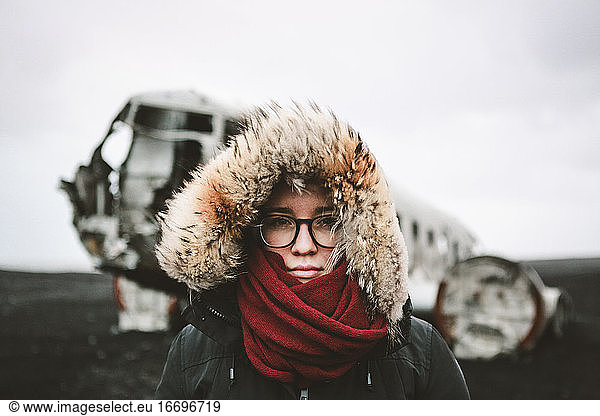 Abenteuerliches Porträt einer jungen Frau vor einem berühmten isländischen Wrack