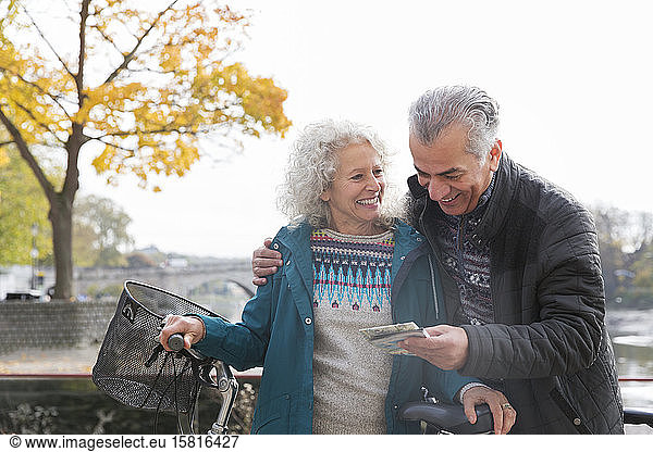 Abenteuerlustiges älteres Ehepaar mit Fahrrädern schaut auf die Karte