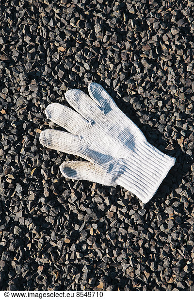 Abgeworfener weißer Handschuh auf dem Boden.