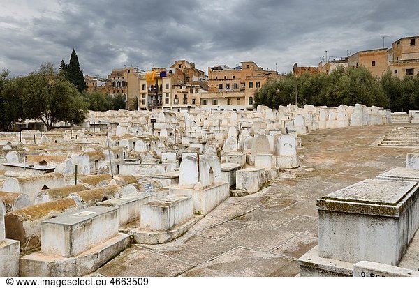 Above ground white tombs in the Mellah Jewish cemetery on a cloudy day in Fes Morocco