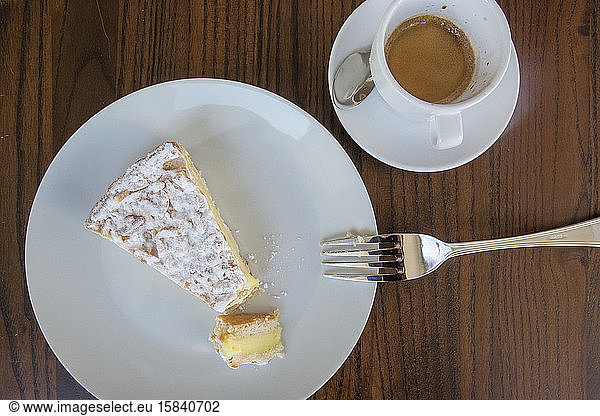 Above-view of a slice of Italian custard cake and a cup of espresso
