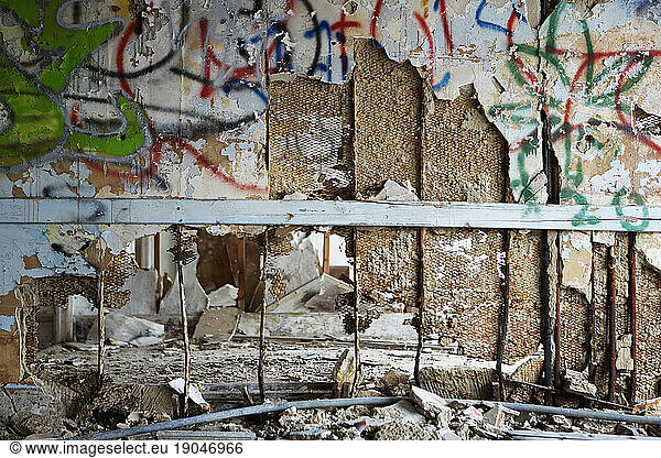 Abstract closeup of a crumbling graffiti covered interior wall.