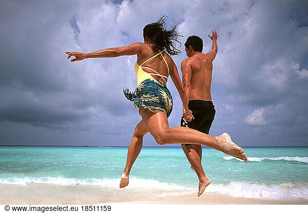 Abstract of fun couple running and jumping in Cancun on beach Mexico
