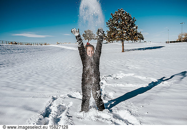 action shot of girl throwing snow in field