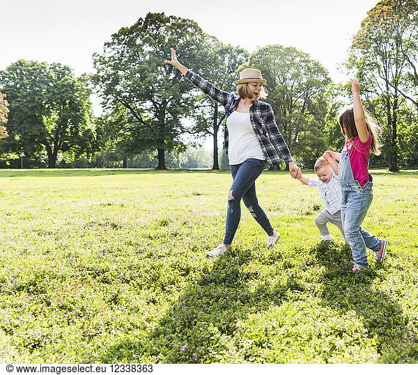 Active happy family walking hand in hand in a park