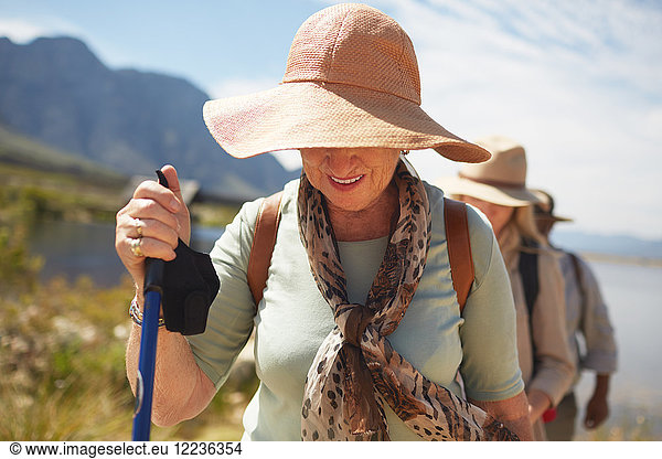 Active senior woman in sun hat hiking