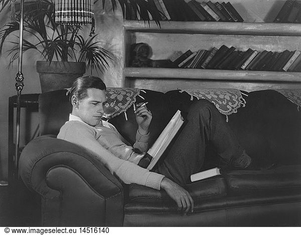 Actor Richard Arlen  Publicity Portrait Smoking Cigarette and Reading Script on Sofa  1930's