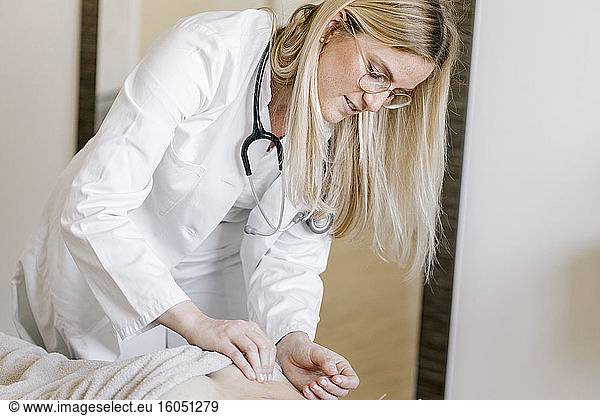 Acupuncture  alternative healthcare worker with acupuncture needle during treatment at back