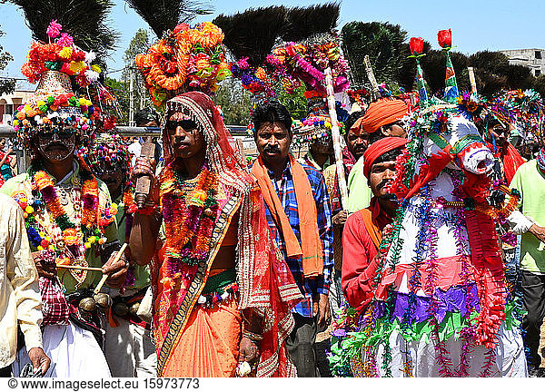 Adivasi tribal men  faces and bodies decorated  wearing ornate headgear  dancing to celebrate Holi festival  Kavant  Gujarat  India  Asia