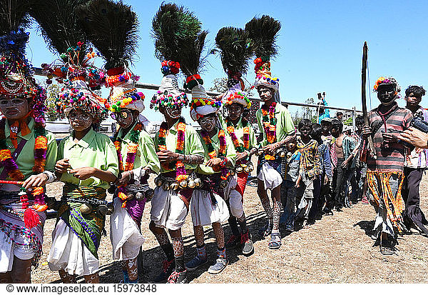 Adivasi tribal men  faces and bodies decorated  wearing ornate headgear  dancing to celebrate Holi festival  Kavant  Gujarat  India  Asia
