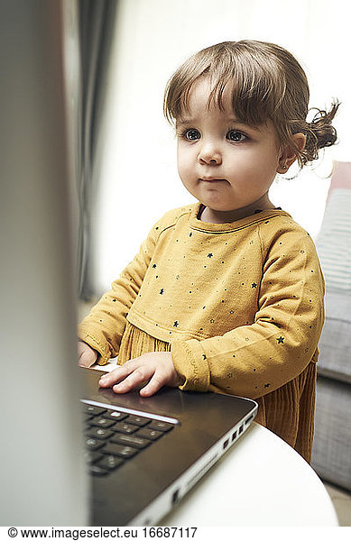 Adorable baby with a laptop