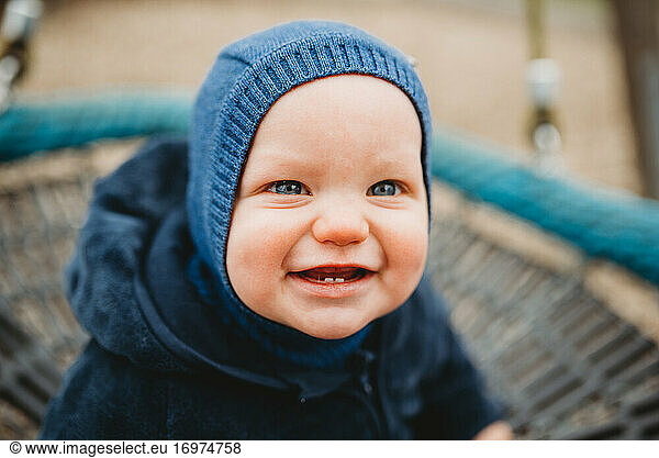 Adorable baby with two front teeth smiling outside in cold winter