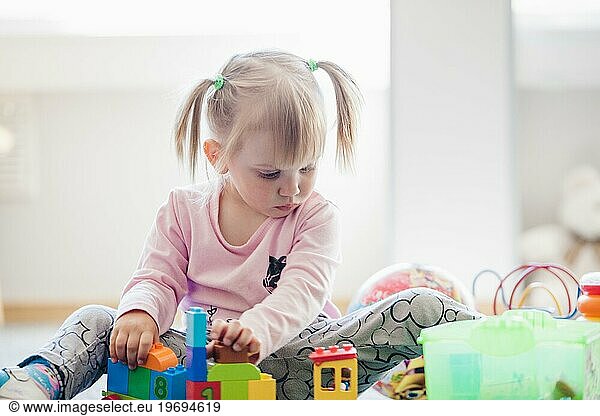 Adorable child with toys playroom