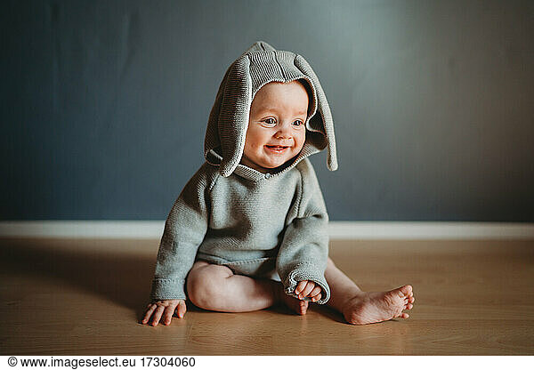 Adorable smiling baby wearing a bunny costume to celebrate Easter