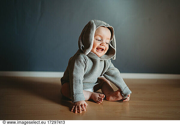 Adorable smiling baby wearing a bunny jumper for Easter