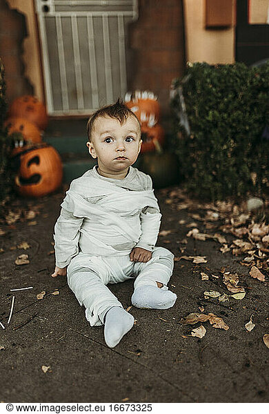 Adorable toddler boy dressed up as mummy on Halloween Trick-or-Treat