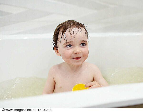 Adorable toddler having fun during evening bath time