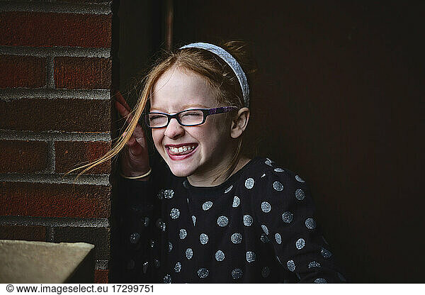 Adorable tween girl with red hair smiling.