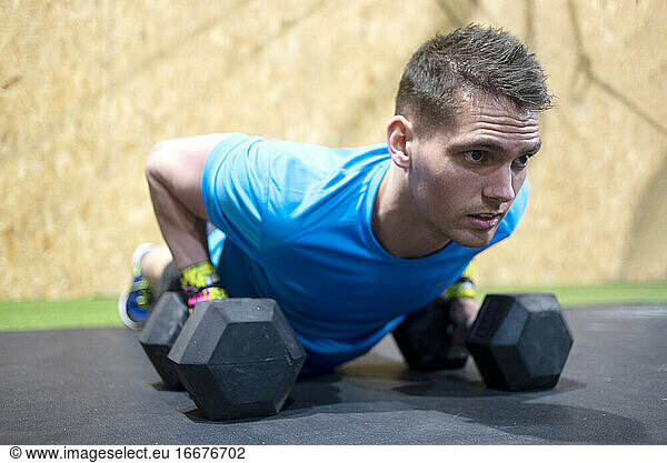 Adult man doing push ups on weights