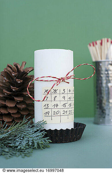 Advent calendar on white decorated candle
