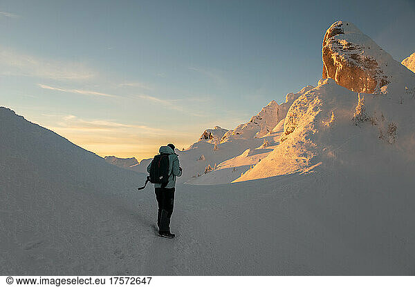 Adventure Photographer Hiking on Frozen Landscape at Sunset
