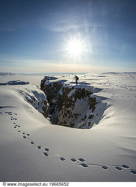 Adventurer standing on edge  Arctic Bay  Nunavut  Canada