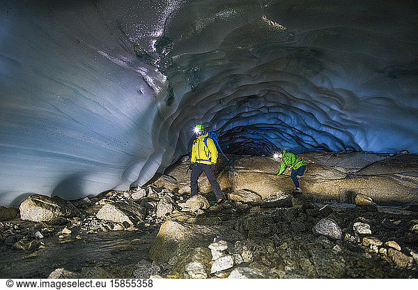 Adventurous couple exploring ice cave near Vancouver.