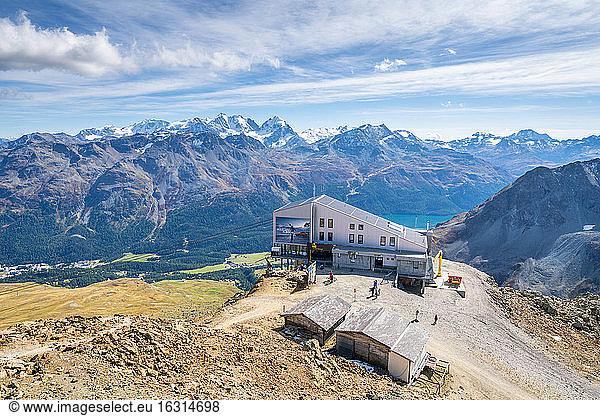 Aerial by drone of tourists at the cable car station on top of rocky peak of Piz Nair  Engadine  canton of Graubunden  Switzerland  Europe
