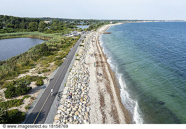 Aerial Drone of Woman biking Cape Cod beaches coastal bike path