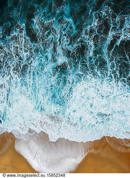 Aerial drone view of beach and ocean waves crashing no people