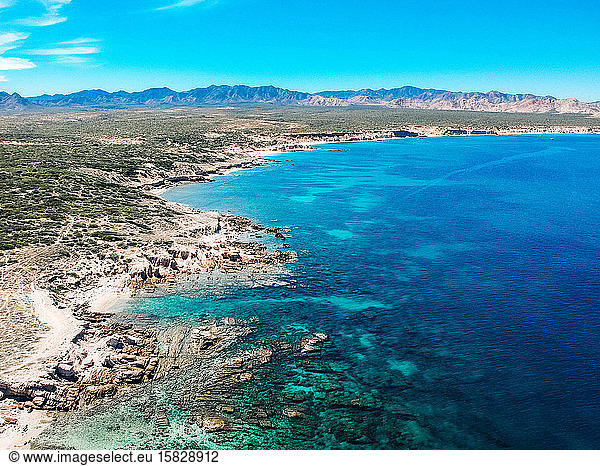 aerial drone view over desert mountains and blue ocean and reef Mexico