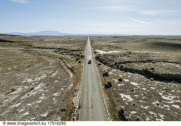 aerial image lonely truck driving on long straight road through desert
