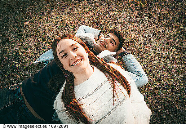 Aerial Shot Of A Happy Couple Lying On The Grass