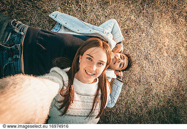 Aerial Shot Of A Smiling Couple Lying On The Grass