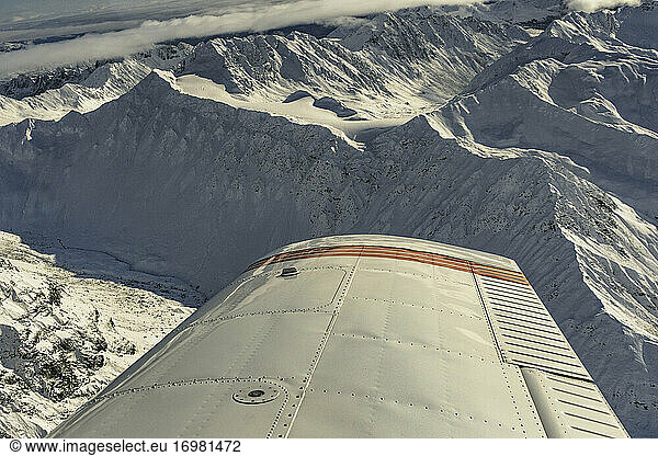 Aerial view of Alaska Range with mountains and airplane wing