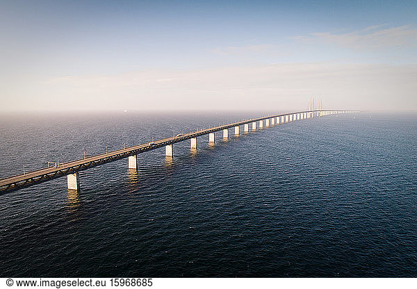 Aerial view of bridge over sea against cloudy sky