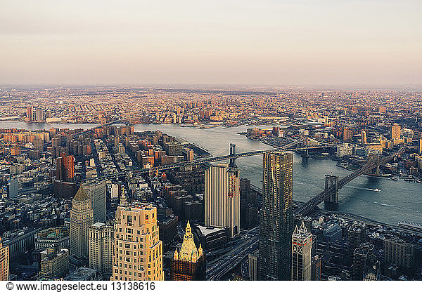 Aerial view of bridges over East river against sky during sunset
