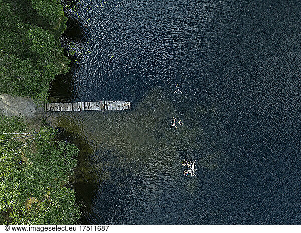 Aerial view of group of people swimming in lake