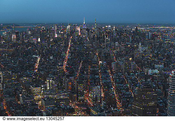 Aerial view of illuminated cityscape against clear sky at dusk