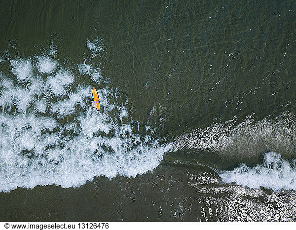 Aerial view of man surfing on sea at Bali