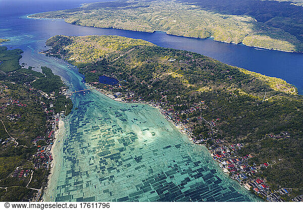 Aerial view of marine farming in turquoise coloured water along a coastline  Komodo National Park; East Nusa Tenggara  Indonesia