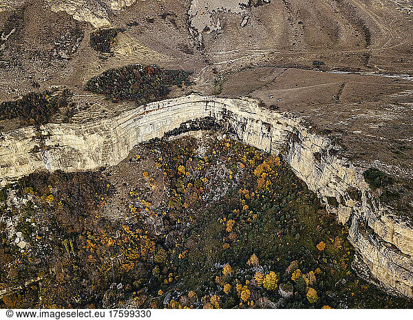 Aerial view of mountain landscape in autumn with steep cliff in center