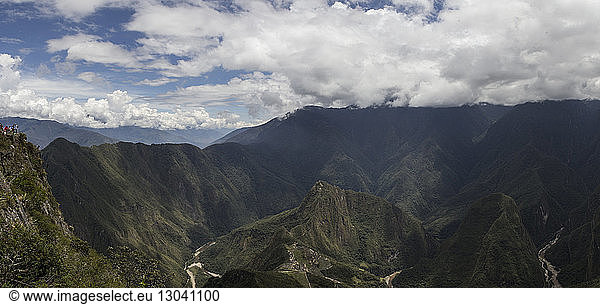 Aerial view of mountain ranges against cloudy sky