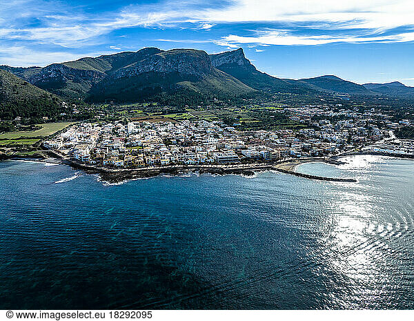 Aerial view of mountain ranges with town and sea under blue sky  Colonia de Sant Pere  Arta  Majorca  Spain