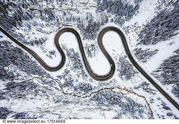 aerial view of mountain road snaking through snow covered Colorado